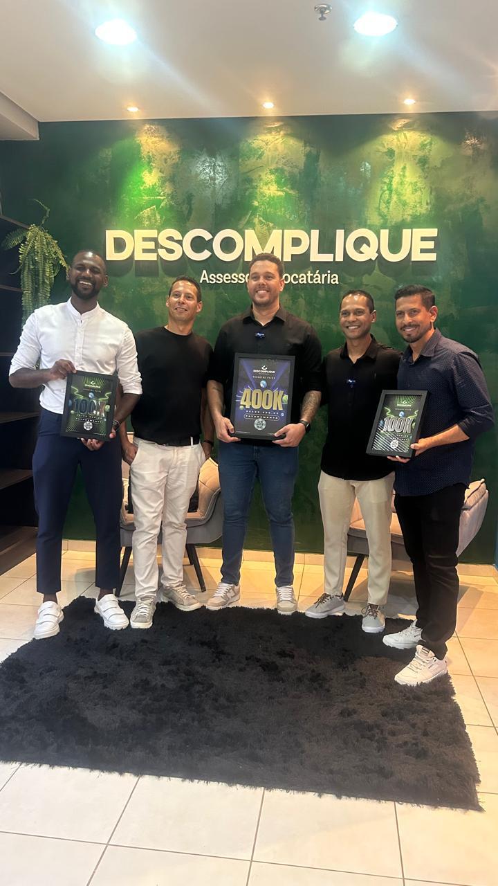 Franqueados da Descomplique com placas de premiação por faturamento